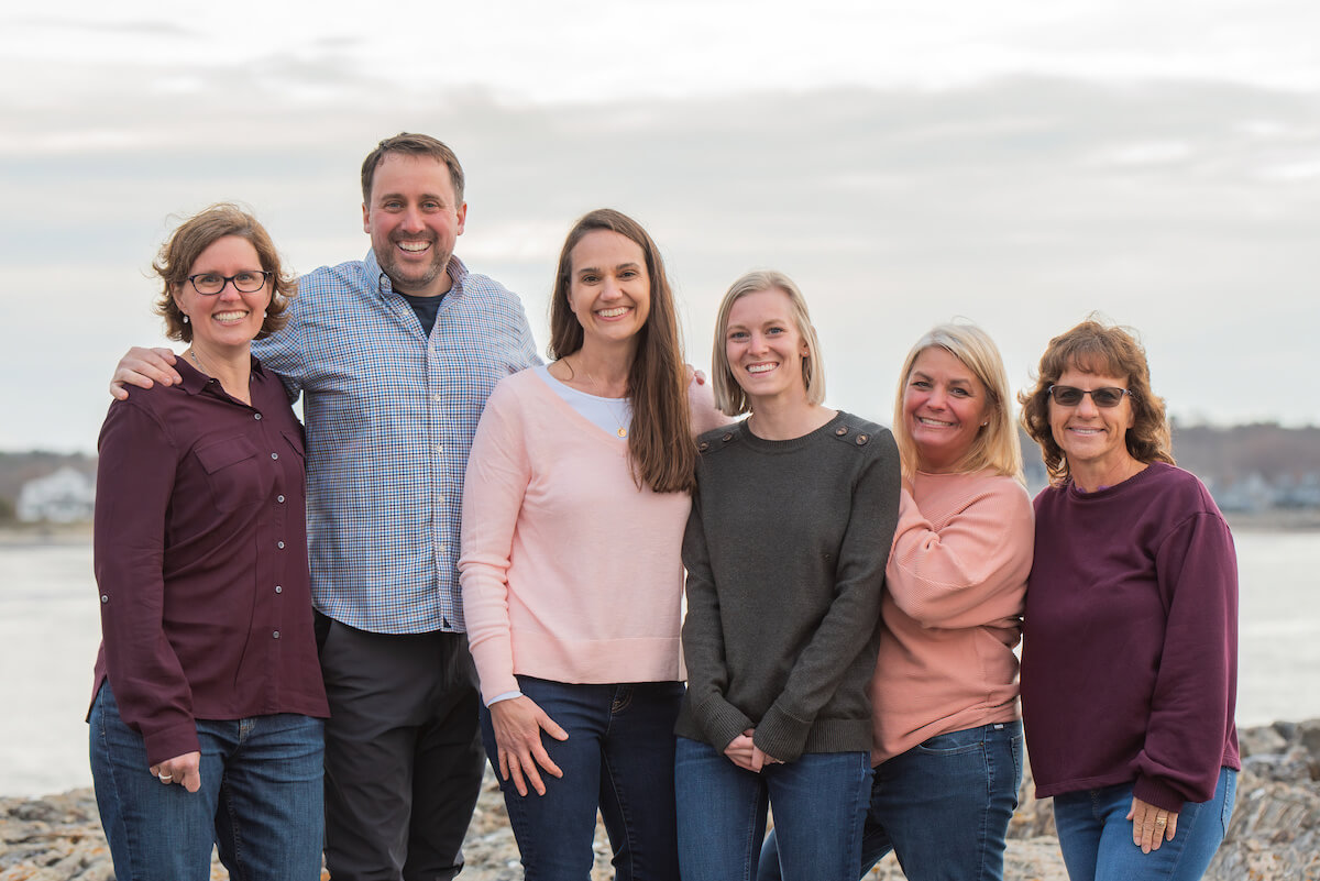 team smiling by shore